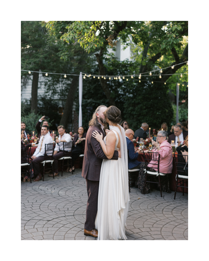 Bride and groom sharing their first dance beneath café lights during an intimate outdoor wedding reception in Charlotte.
