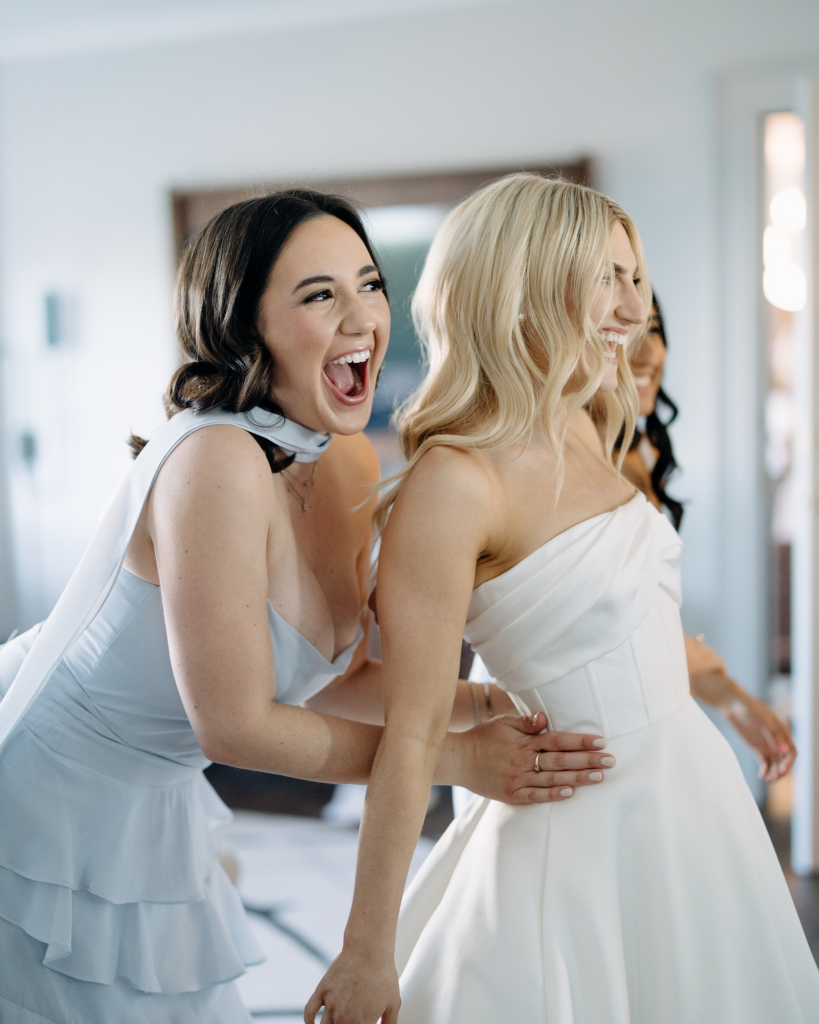 bride and bridesmaid celebrating before wedding ceremony