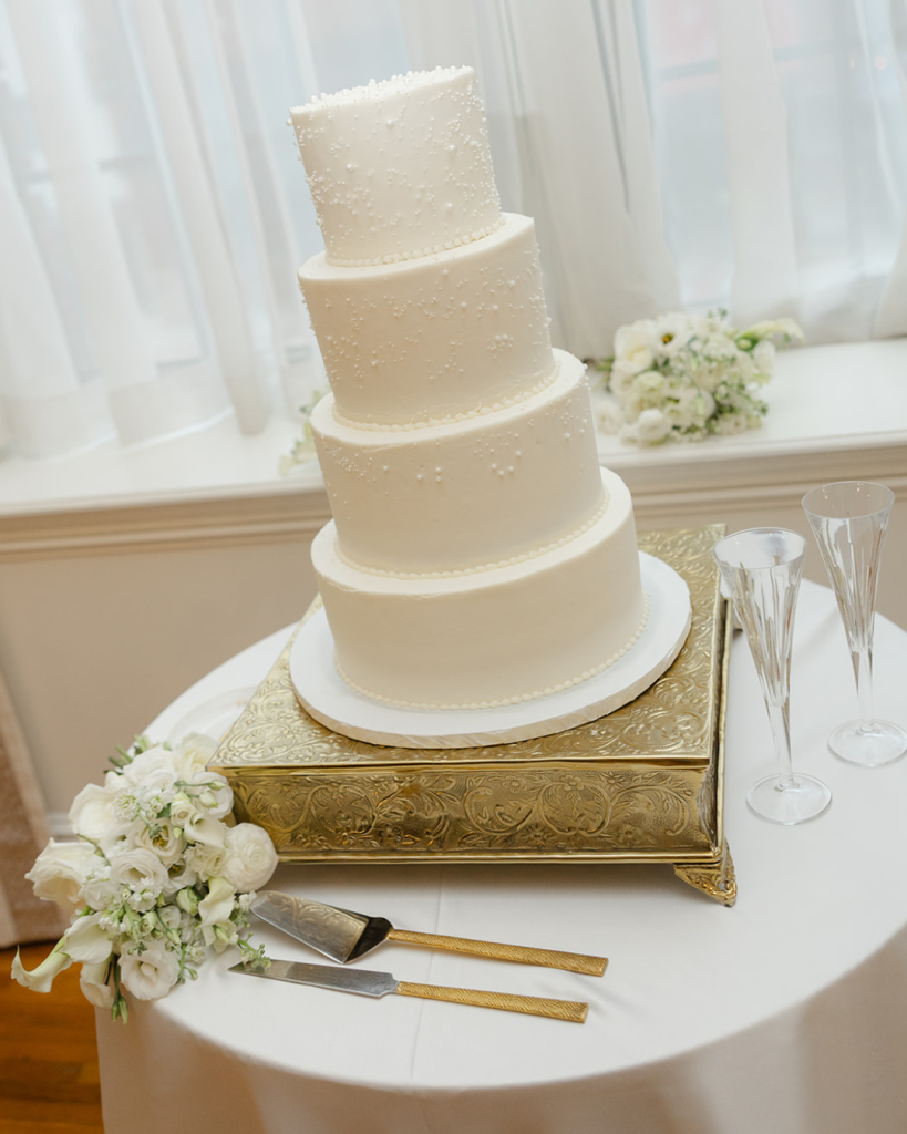 White pearl detailed wedding cake displayed during modern black and white wedding reception in Concord North Carolina.