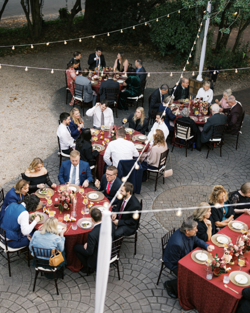 Guests dining beneath string lights during an outdoor courtyard wedding reception at The Morehead Inn in Charlotte, North Carolina.
