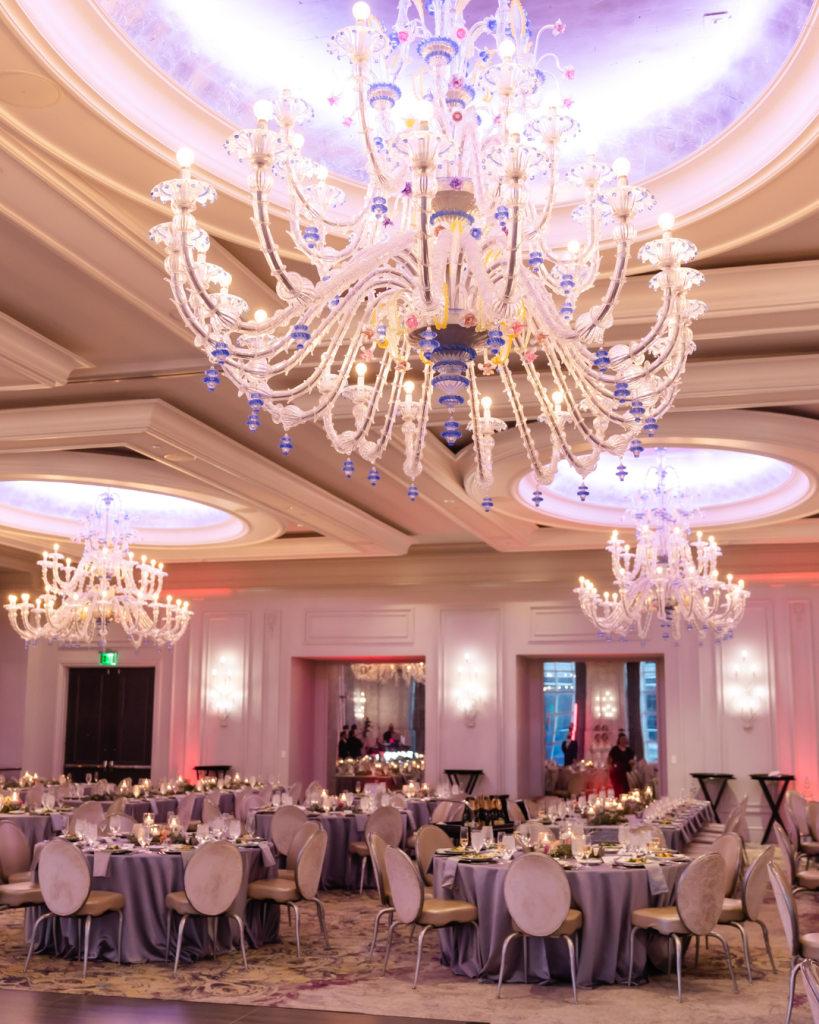 Luxury wedding reception ballroom with chandeliers, romantic lighting, and elegant tablescape design at Grand Bohemian Charlotte wedding venue.
