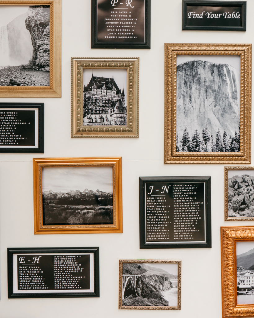 Elegant seating chart installation featuring framed black and white artwork and guest seating assignments at a Charlotte wedding reception.
