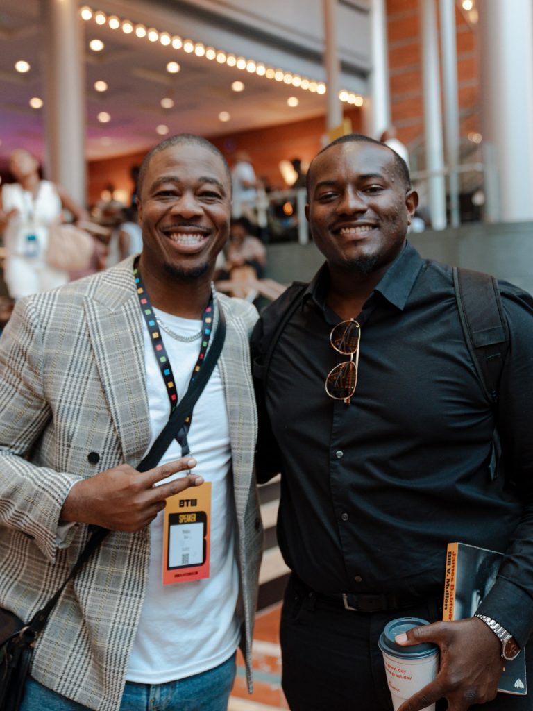 Anthony Saxson posing with a fellow attendee at a music industry event.