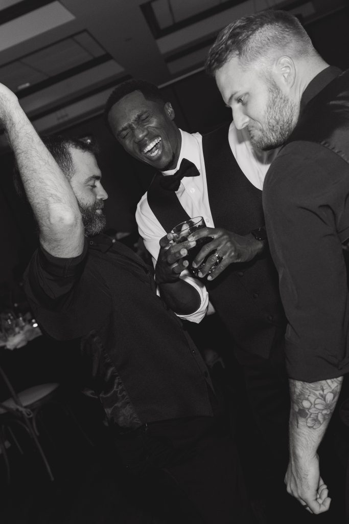 Groom on the dance floor surrounded by groomsmen dancing while Spin Society DJs get the party alive.