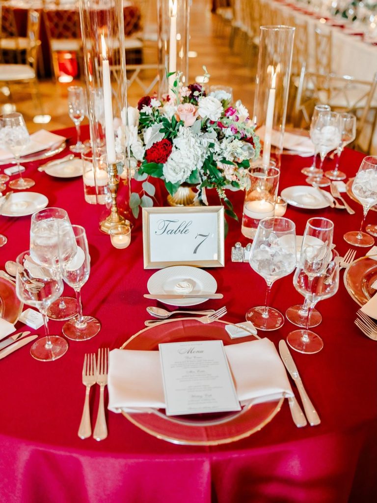 Reception details showcasing red linens and gold accents executed by Hawthorne Creative Co.