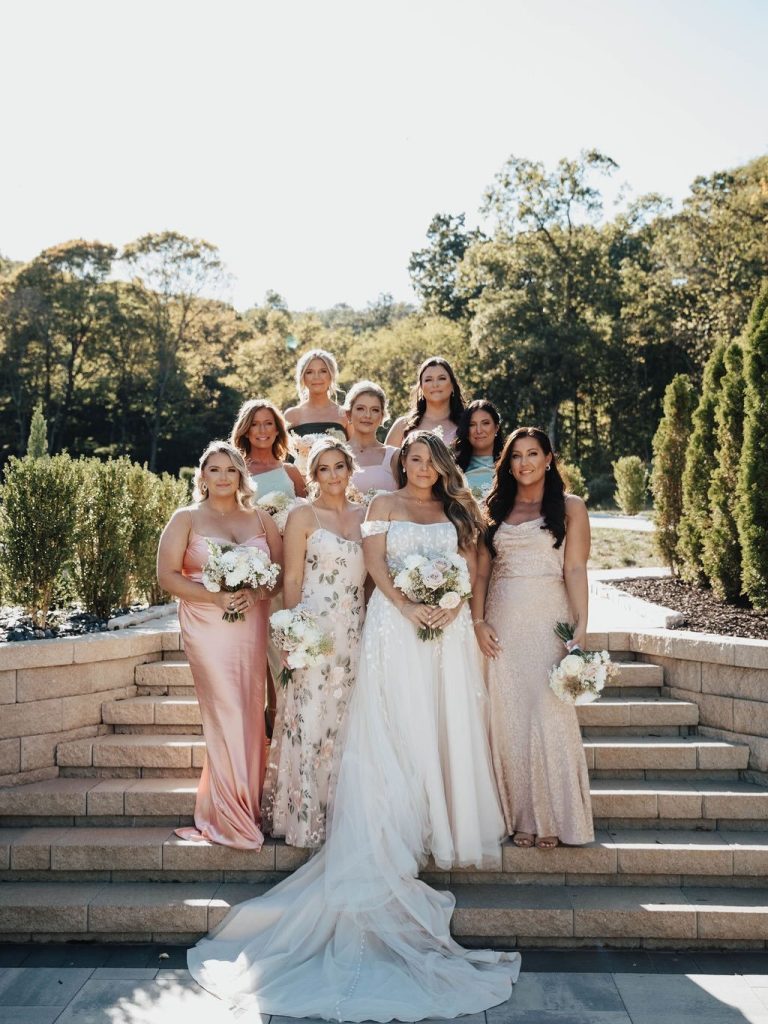 Bride and her bridesmaids standing on the stairs at Knotting Hills Wedding Venue & Resort. Captured by Blue Willow Photo & Video.