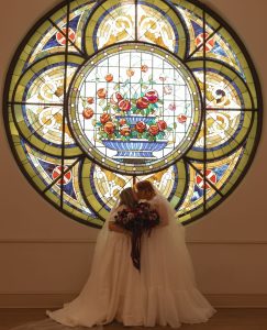 two brides kissing at The Elliot under the stained glass