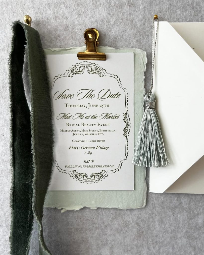 Elegant bridal beauty event invitation featuring ornate calligraphy typography, handmade paper details, soft ribbon styling, and tassel accents promoting the Meet Me at the Market event in German Village.