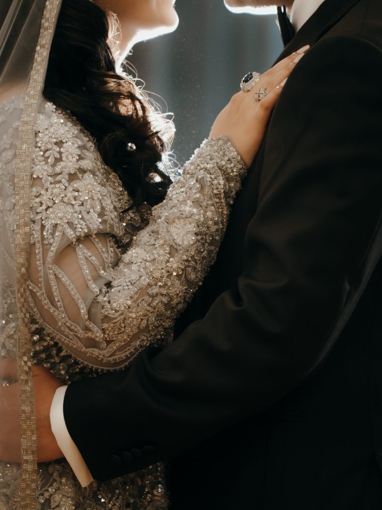 Close up detail photo of bride and groom embracing