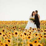 Bride and groom posing in sunflower field
