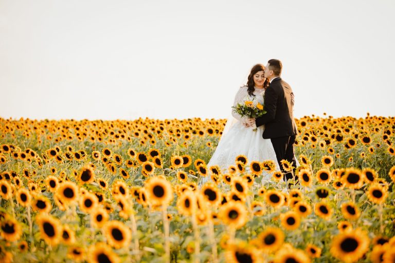 Bride and groom posing in sunflower field