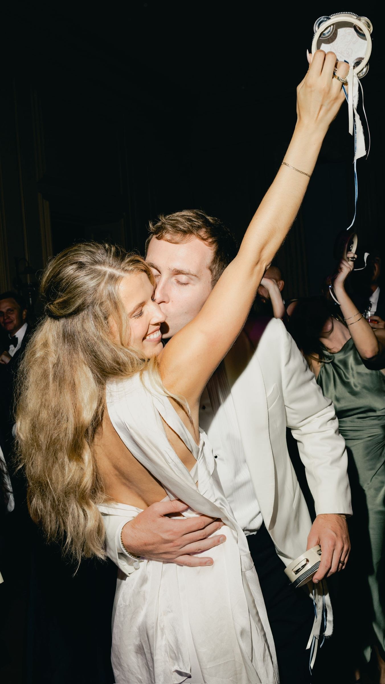 Husband and wife kissing on dance floor during wedding reception