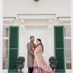 bride and groom posing in front of green shutters at outdoor wedding venue