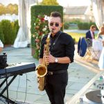 Man playing sax at outdoor wedding venue