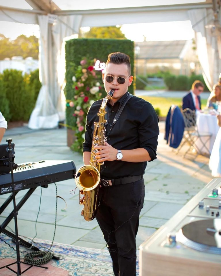 Man playing sax at outdoor wedding venue