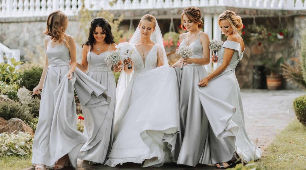bride and bridesmaids in grey walking at outdoor wedding venue in northern virginia
