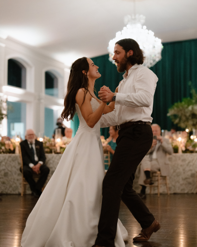 Bride and Groom first dance in white mansion surrounded by live trees and green drapery
