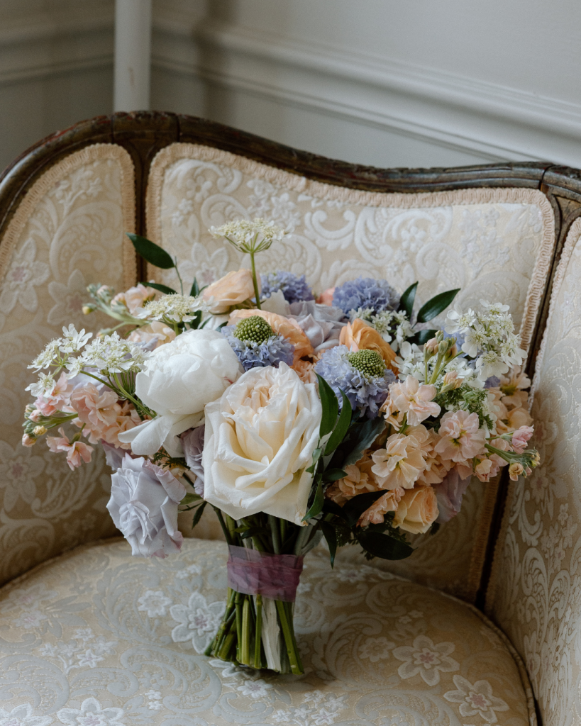 lavender, peach, and sage wedding bouquet against couch getting ready photos