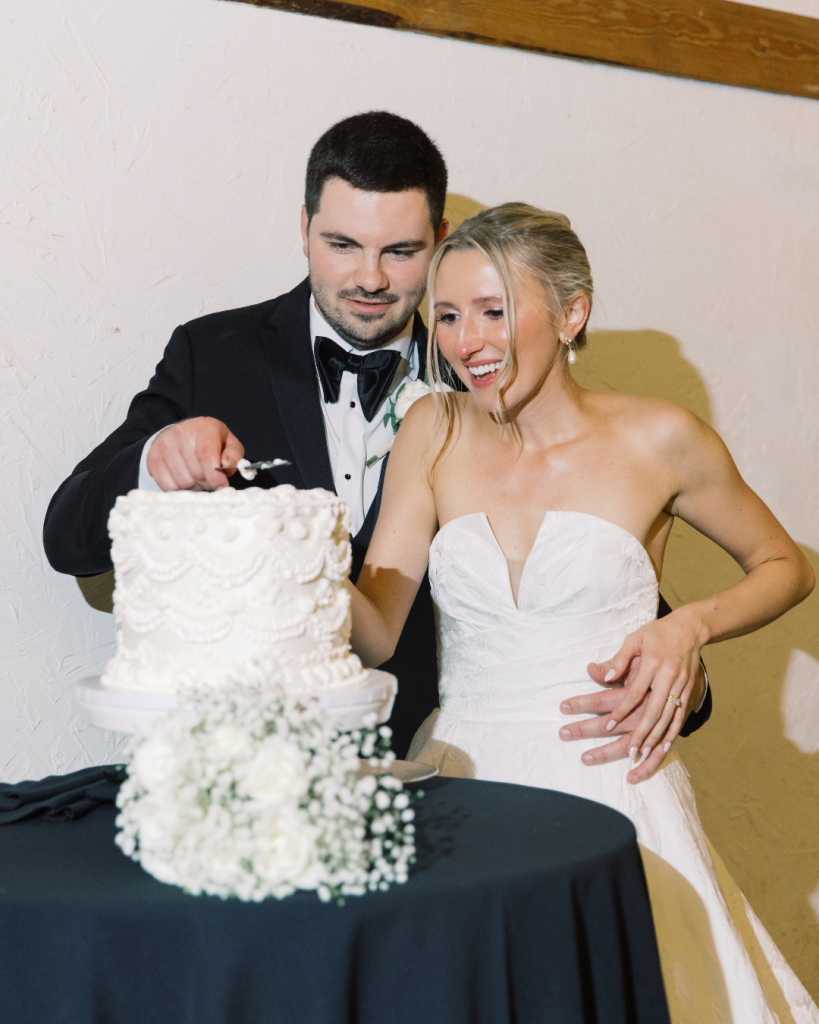 bride and groom laughing cutting cake indoor wedding venue great marsh estate