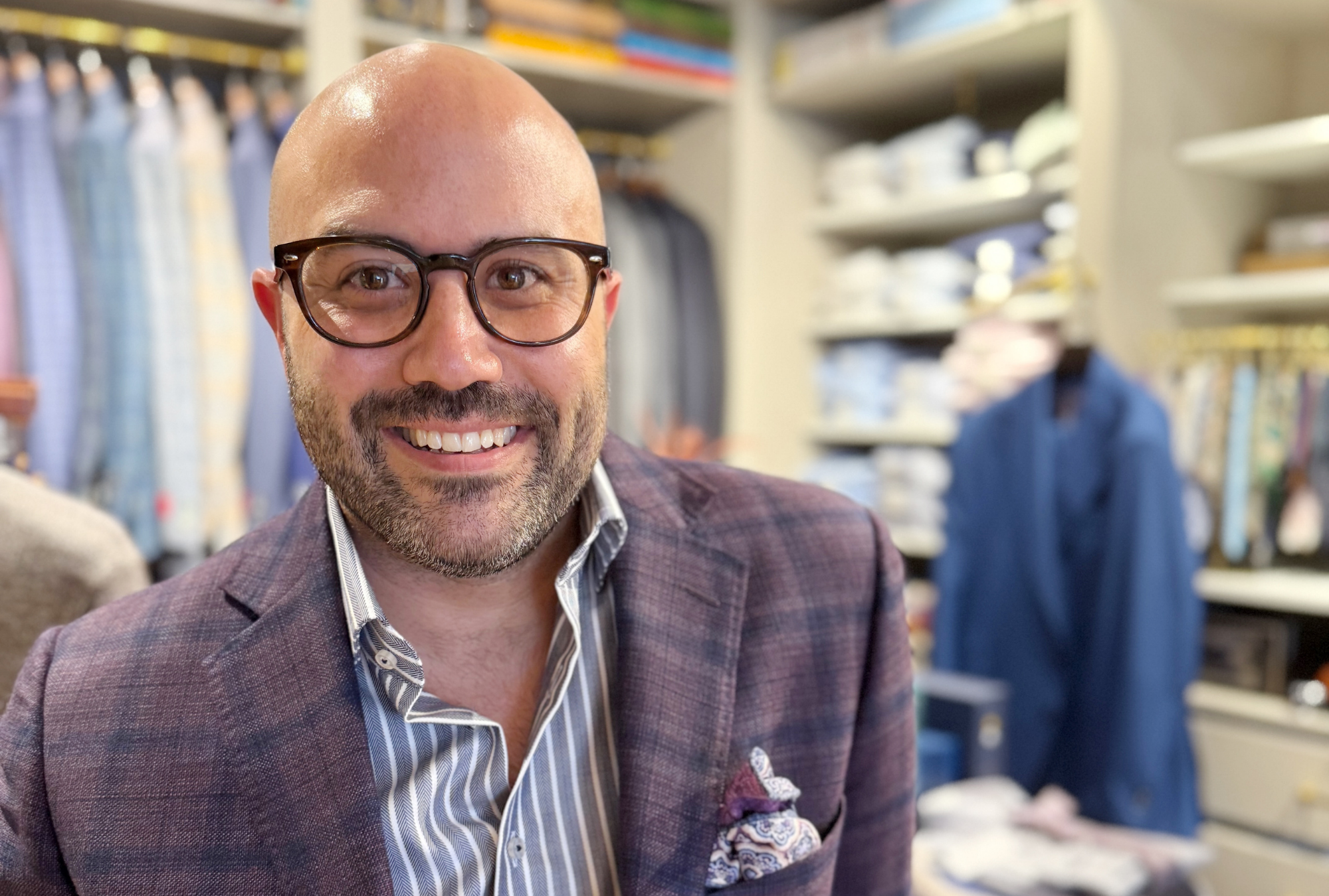 Portrait of Young & Squire founder Kevin Yonker inside his Greenville, Delaware menswear studio surrounded by custom garments and tailoring displays.