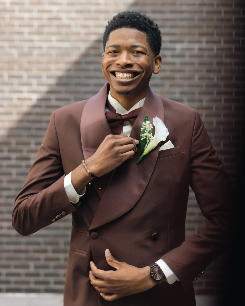 Groom portrait in a chocolate brown tuxedo with shawl lapels and white floral boutonniere during a wedding at The Lumen House near Charlotte, NC.