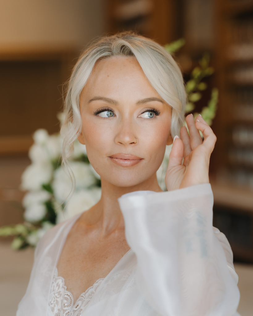 Classic bridal portrait of Danielle in soft natural light featuring timeless wedding makeup, an elegant updo, and a lace bridal robe before her wedding at The Ruth in Charlotte.