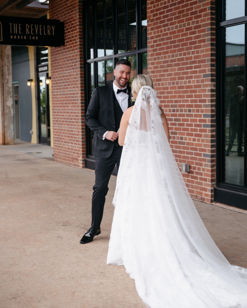 Bride and groom share a candid first look moment outside The Revelry wedding venue in Charlotte, NC.