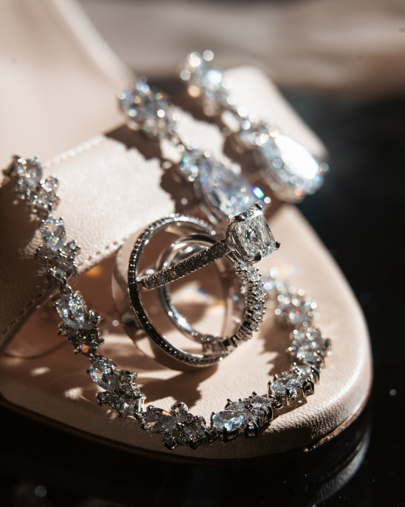 Close up of wedding rings, bridal jewelry, and sparkling accessories styled for a glamorous Charlotte wedding editorial.