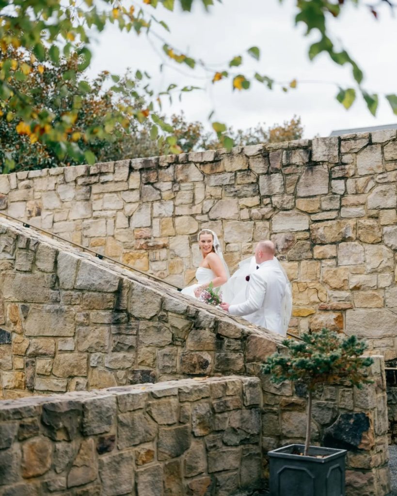 husband and wife walking up stone stairs at resort in northern virginia