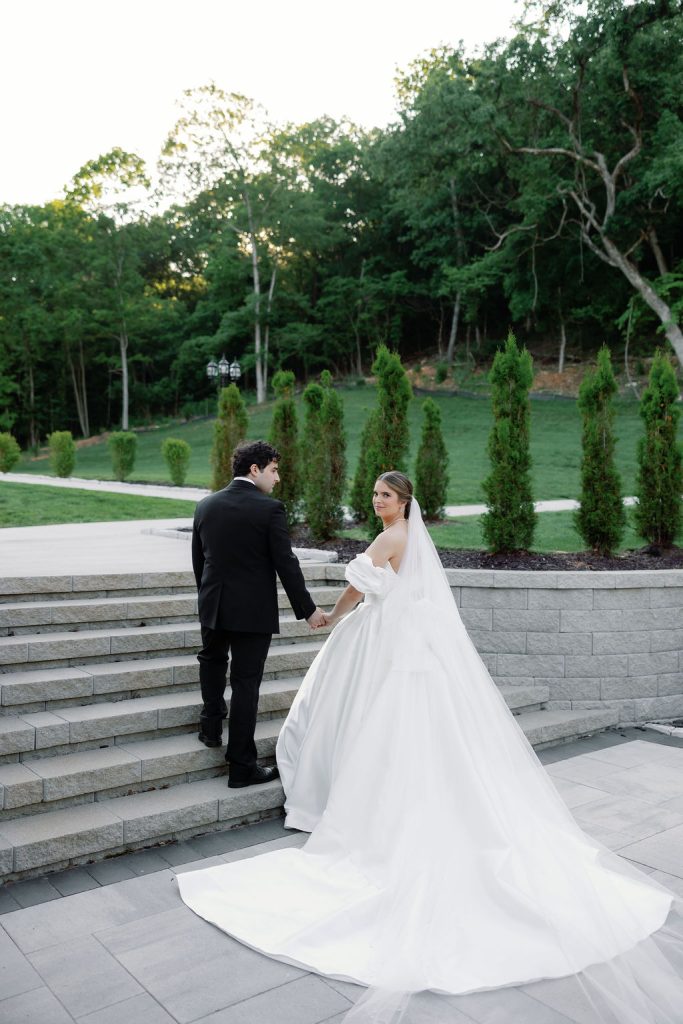 Bride and groom walking up the stairs at the European-inspired Knotting Hills Wedding Venue & Resort.