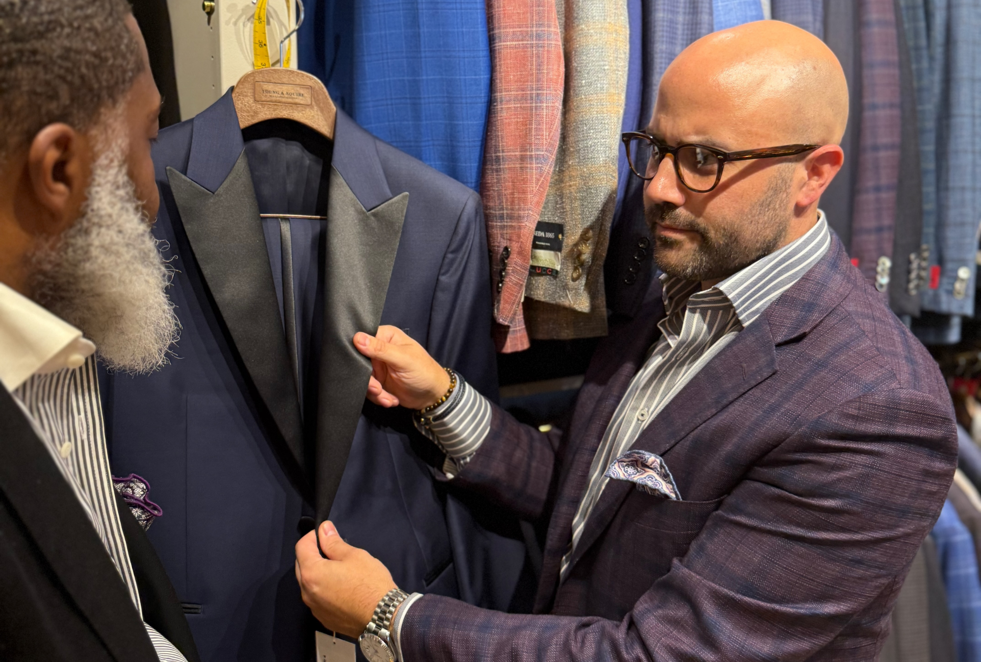 Kevin Yonker discussing suit styling and fabric selections with a client inside the Young & Squire bespoke menswear studio in Delaware.