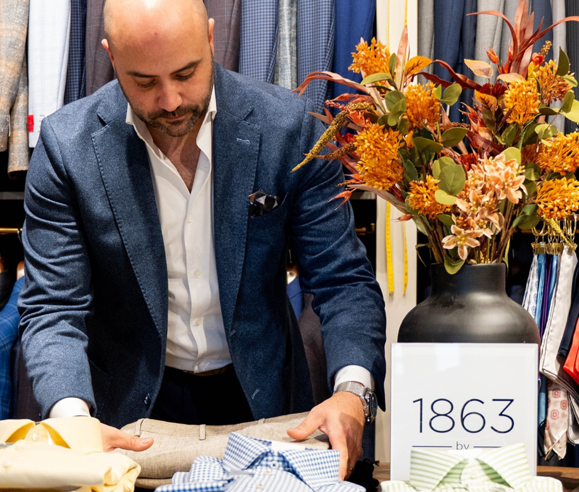 Kevin Yonker arranging garments and styling pieces inside the Young & Squire tailoring studio in Greenville, Delaware.