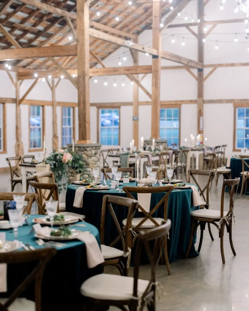 indoor wedding reception space in northern virginia with windowed walls and wood accents. green tablescape with dark brown chavari charts