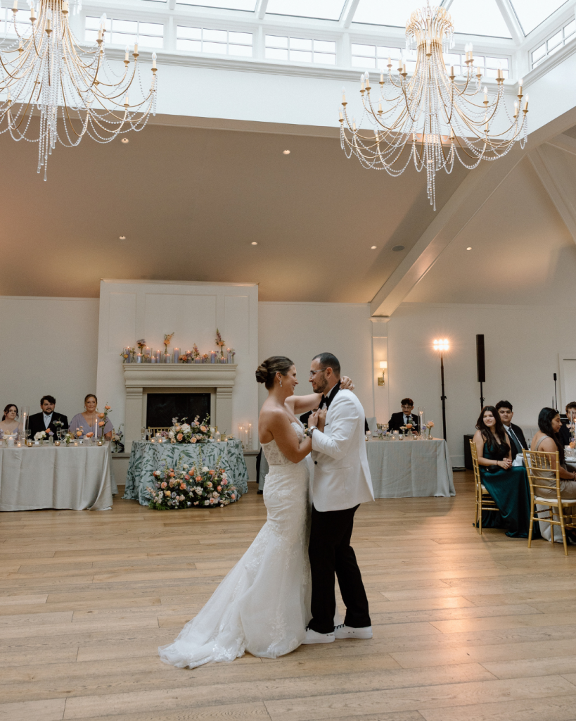first dance as husband and wife in ballroom of historic wedding venue with fire place and chandelier