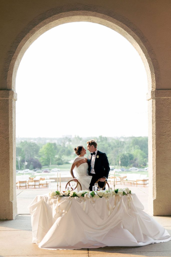 Bride and groom standing near sweat heart table with decor and rentals provided by Exclusive Events, Inc.
