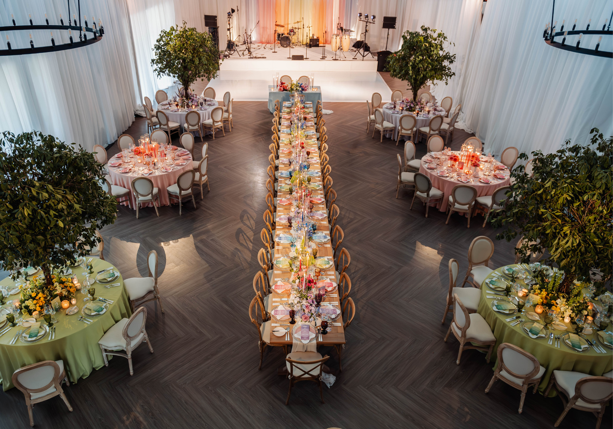 The Farmstead at Kent Island Resort transformed with white draping, colorful reception tables, floral centerpieces, and tree installations.