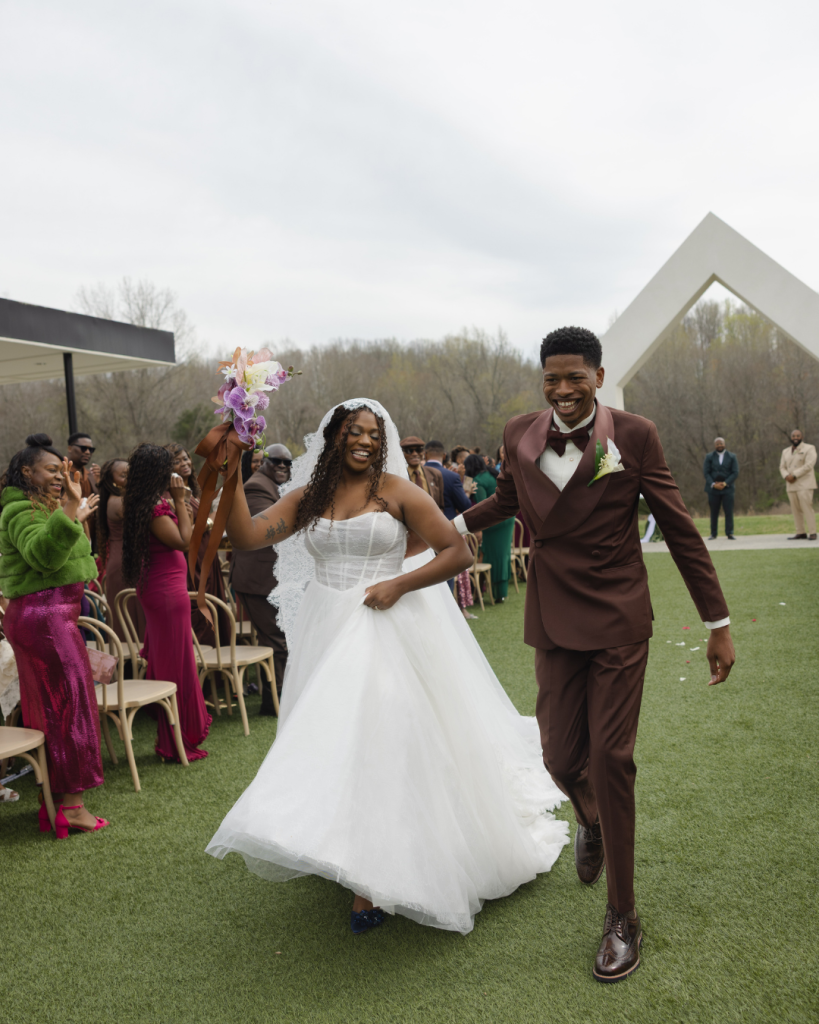 Bride and groom celebrate their recessional at The Lumen House in Cleveland, North Carolina as guests cheer from both sides of the aisle. Featured on Wed Society Charlotte.