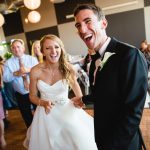 Bride and groom laughing together on the dance floor during their wedding reception.
