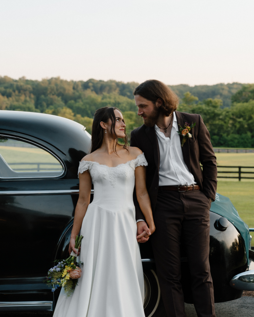 husband and wife leaning on vintage car in northern virginia