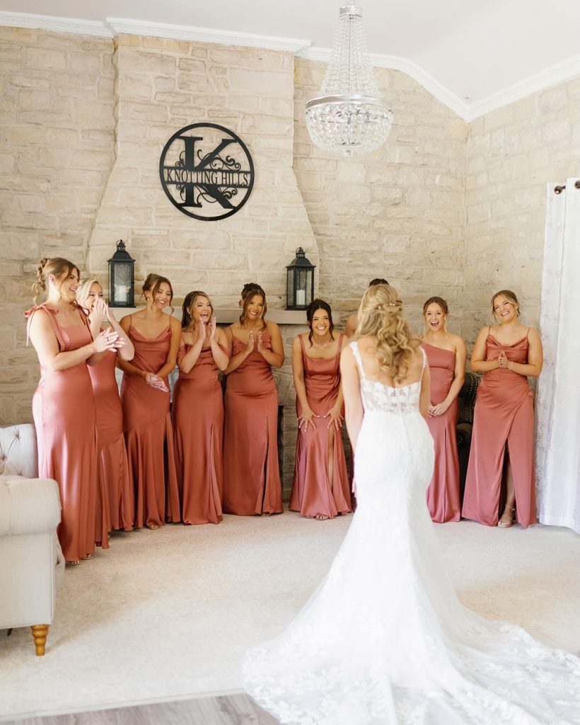 Bridesmaids first look at bride in the light and airy bridal suite at Knotting Hills Wedding Venue & Resort.