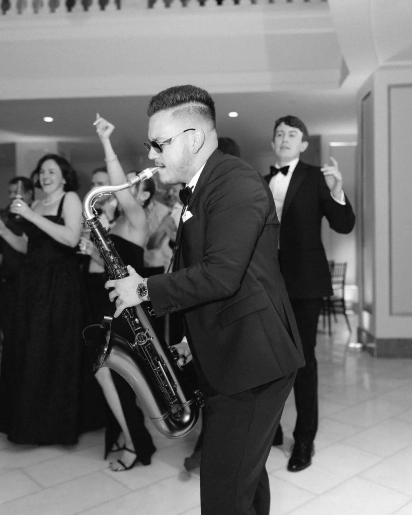 live saxophone player playing for wedding reception with guests on wedding dance floor