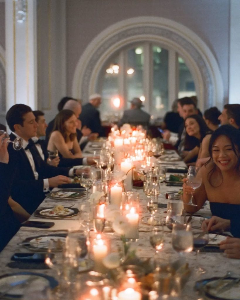 long rectangular table of wedding guests and candlelit dinner at museum