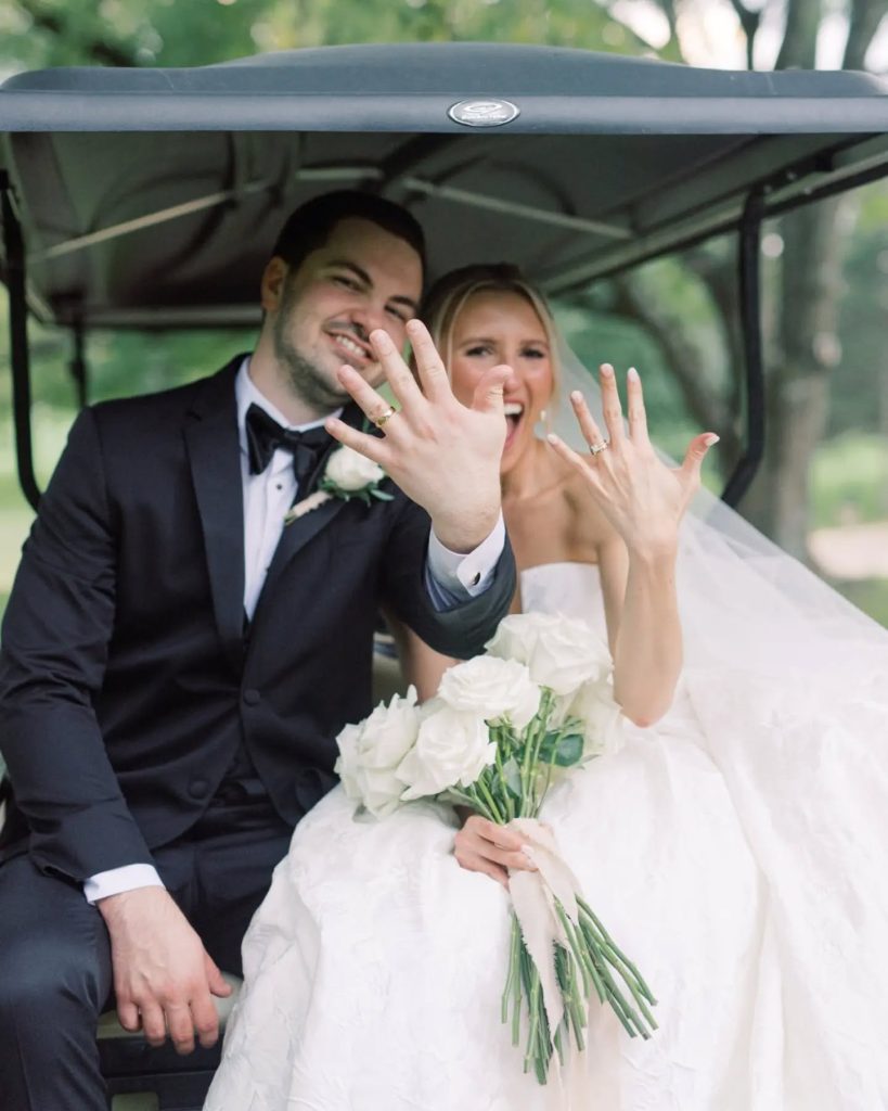 bride and groom showing off wedding rings in golf cart after ceremony northern virginia