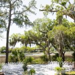 Outdoor wedding inspiration featuring a waterfront ceremony site, modern white chairs, and garden chic floral details.