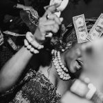 Cultural wedding inspiration showing a bride in traditional attire during a lively wedding reception money spray dance.