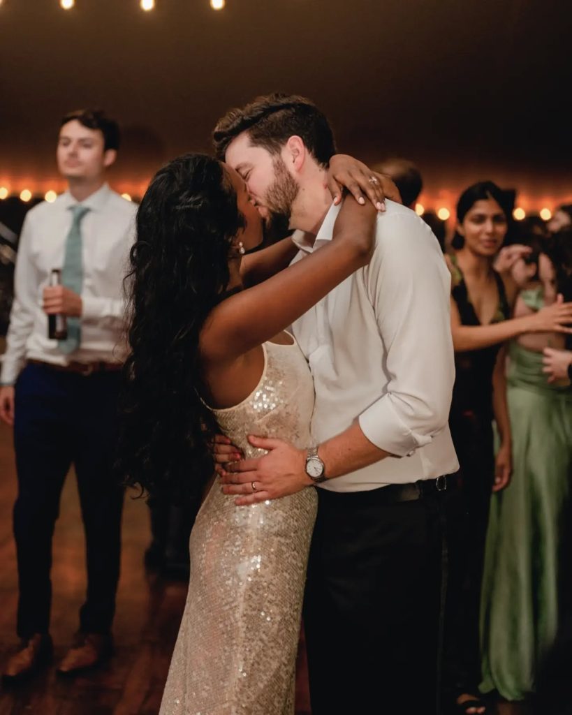 bride and groom kissing on the dance floor in second change dress wedding night