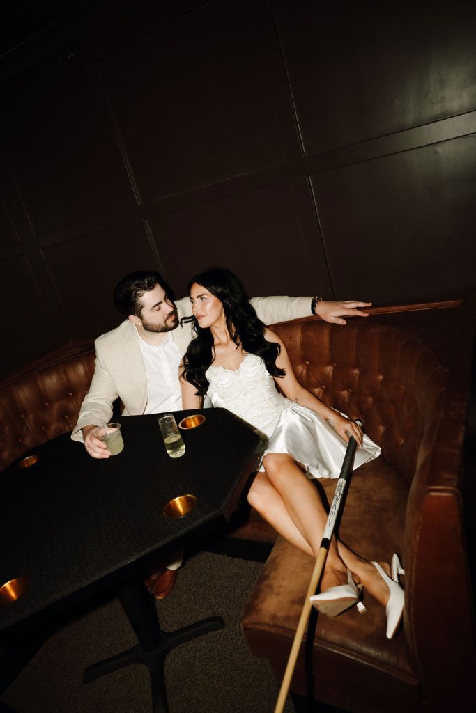 Moody photo of bride and groom in a pool lounge captured by Desert Luna Photo.