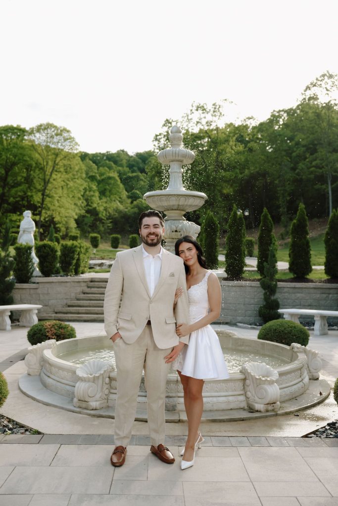 Bride and groom posing in front of a grand fountain at Knotting Hills captured by Desert Luna Photo.