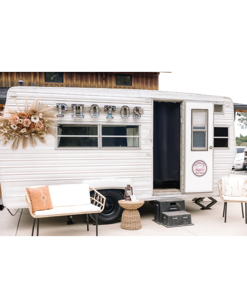 Vintage white photo booth trailer decorated with dried florals outside the Camelot Meadows reception in Charlotte.