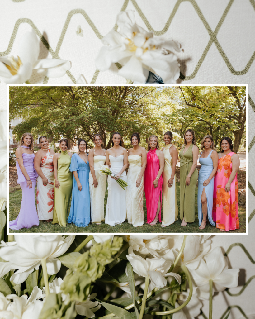 Bride poses with bridesmaids wearing colorful spring dresses surrounded by white florals at The VanLandingham Estate wedding.